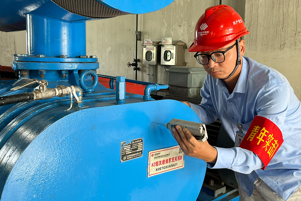 圖為青年人員檢查粗灰磨制系統(tǒng)設(shè)備運(yùn)行情況